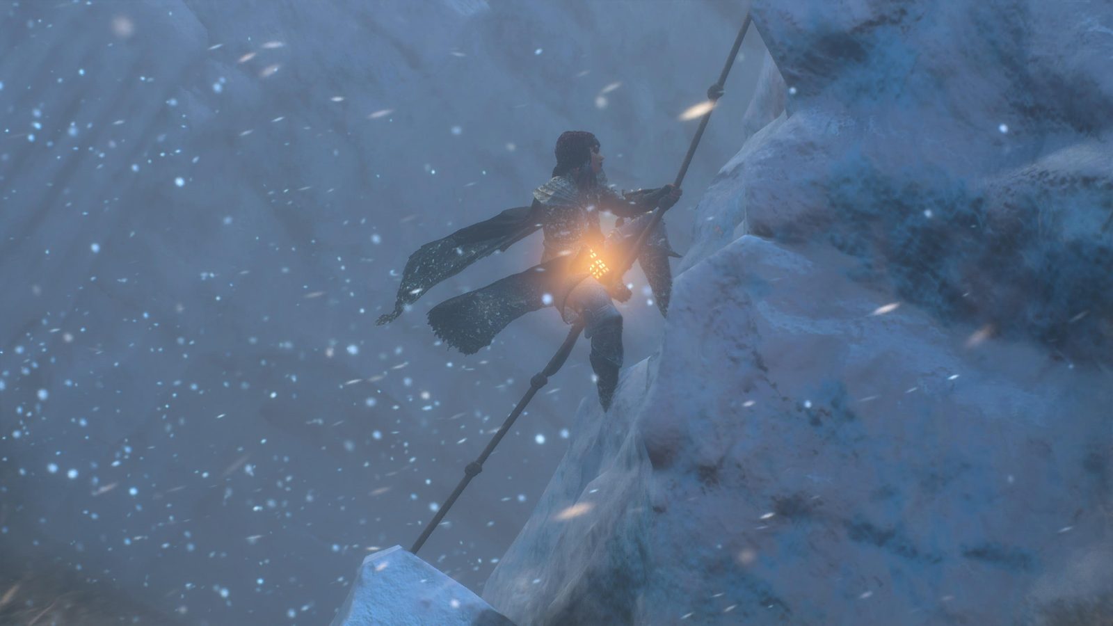 DRAGON'S DOGMA 2: DARK ARISEN, LA VERSION ULTIME DU JEU DE CAPCOM Escalade d'une falaise enneigée le long d'un cordage, lanterne allumée à la ceinture, dans le blizzard de Norgan